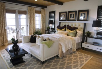 White bedroom with a patterned rug.