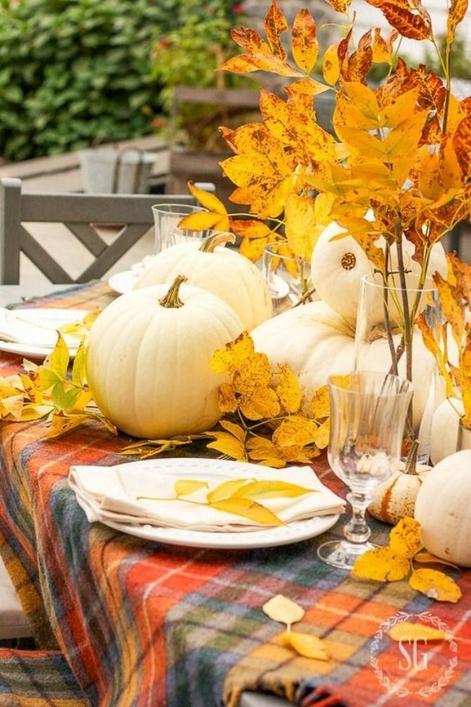 Fall table setting with pumpkins and leaves.